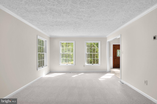 carpeted spare room with baseboards, ornamental molding, a textured ceiling, and visible vents