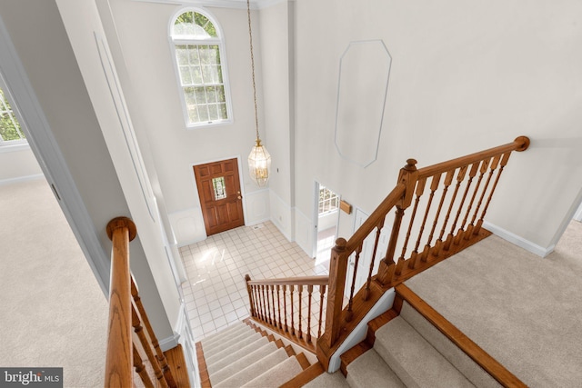 foyer featuring carpet floors, baseboards, and stairs