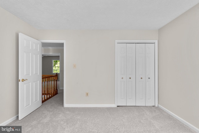 unfurnished bedroom featuring baseboards, carpet flooring, and a closet