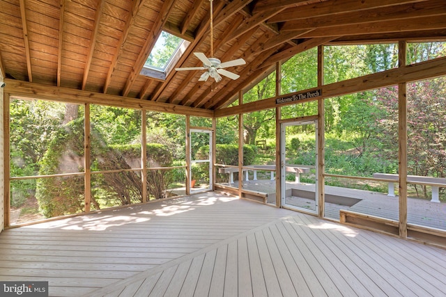 unfurnished sunroom featuring a skylight, plenty of natural light, and a ceiling fan