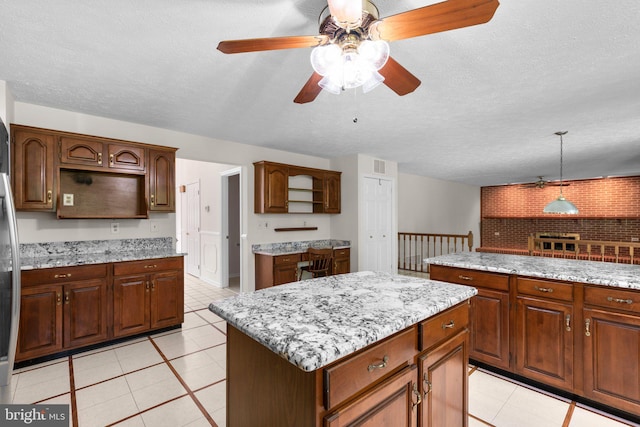 kitchen featuring light tile patterned floors, a center island, ceiling fan, and open shelves