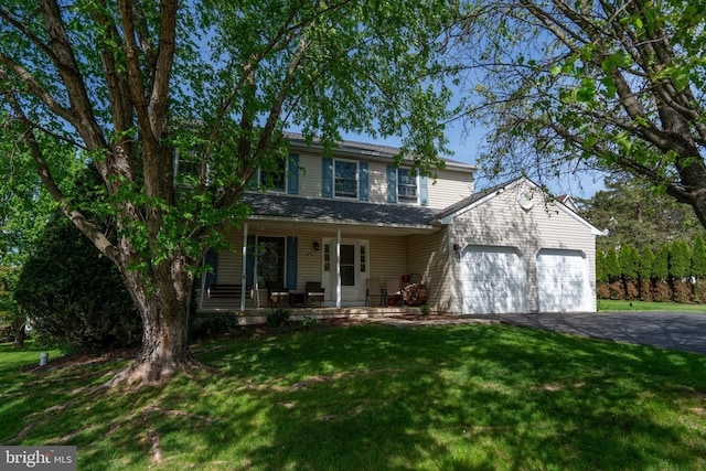1069 E 2nd St, Red Hill, PA 18076 - traditional-style house with covered porch, an attached garage, driveway, and a front lawn