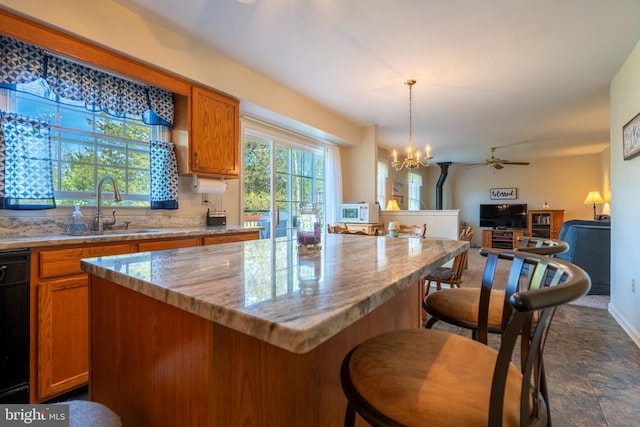 1069 E 2nd St, Red Hill, PA 18076 - kitchen with brown cabinetry, a kitchen island, light stone countertops, a sink, and open floor plan