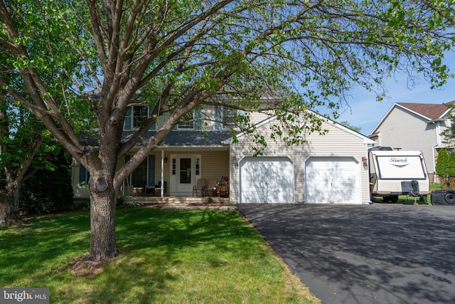 1069 E 2nd St, Red Hill, PA 18076 - view of front of house featuring a porch, a garage, aphalt driveway, and a front yard
