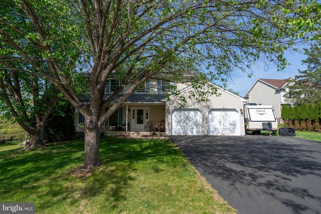 1069 E 2nd St, Red Hill, PA 18076 - obstructed view of property featuring an attached garage, a front lawn, aphalt driveway, and covered porch