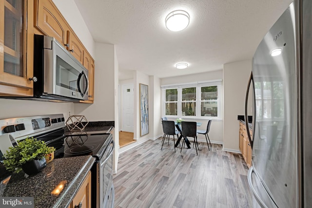 9120 Galbreth Ct, Springfield, VA 22153 - kitchen featuring stainless steel appliances, light wood-type flooring, glass insert cabinets, baseboards, and a textured ceiling