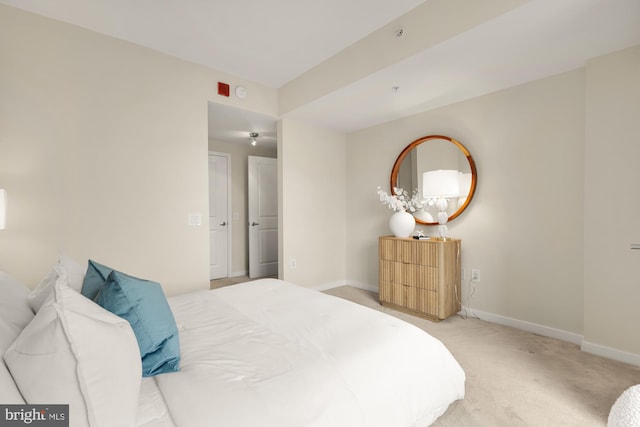 bedroom featuring light carpet and baseboards