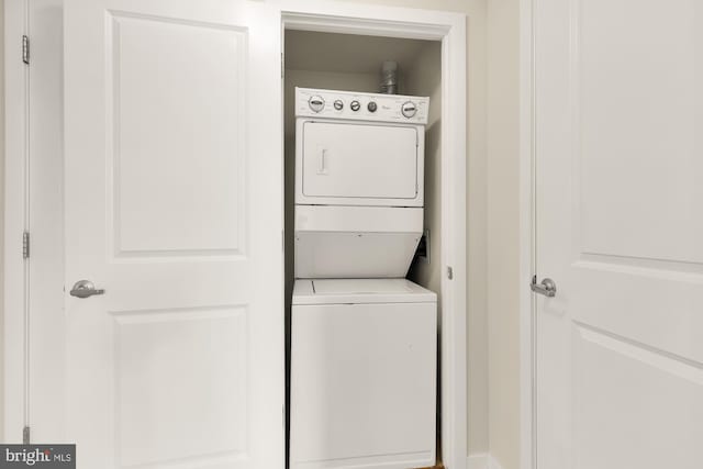 washroom with stacked washer / dryer and laundry area