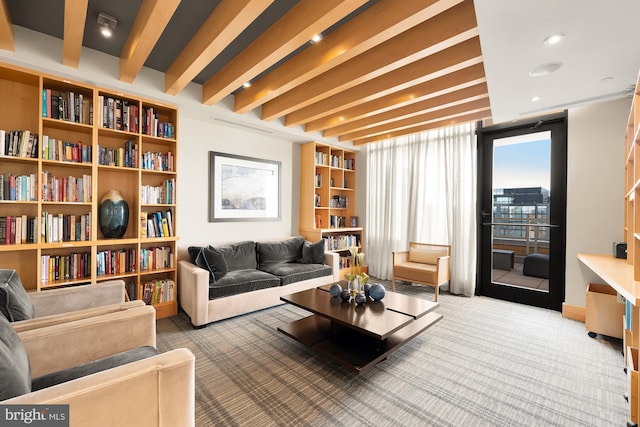 living area featuring beamed ceiling and carpet
