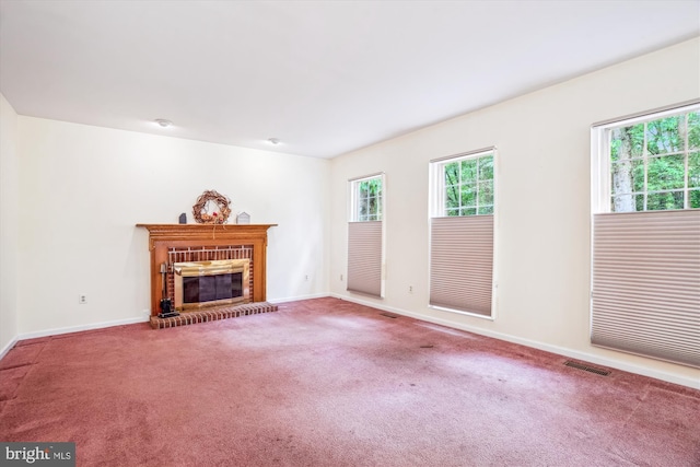 unfurnished living room featuring carpet flooring, baseboards, and a fireplace