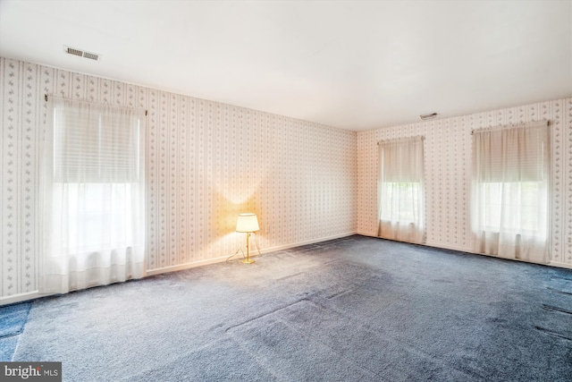 empty room featuring wallpapered walls and carpet floors