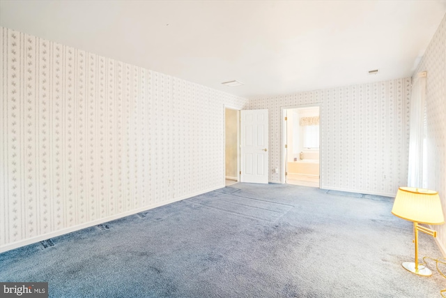 spare room featuring wallpapered walls and carpet floors