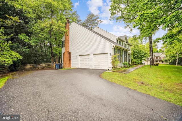 view of side of home featuring driveway and a chimney
