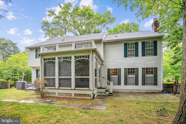 back of property featuring a sunroom, a chimney, and central AC