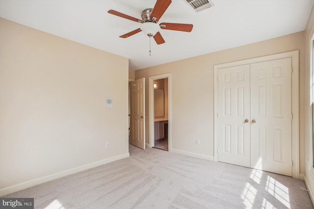 unfurnished bedroom featuring visible vents, baseboards, a closet, connected bathroom, and light carpet