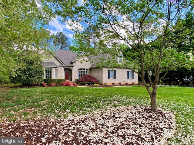 view of front of home featuring brick siding and a front yard