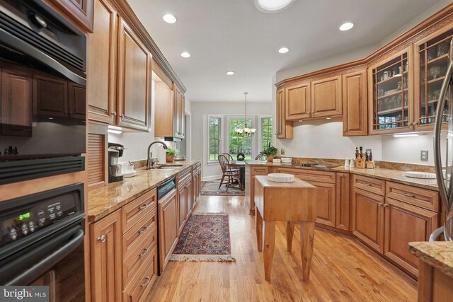 kitchen with recessed lighting, light wood finished floors, a sink, and black appliances