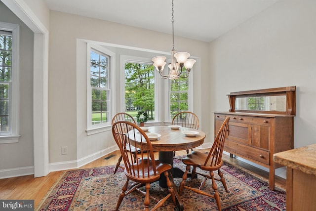 dining room featuring an inviting chandelier, baseboards, light wood-style flooring, and visible vents