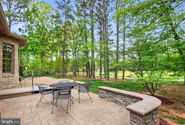 view of patio with outdoor dining area and a wooden deck