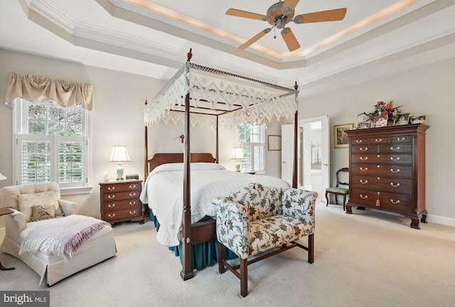 bedroom with crown molding, a raised ceiling, carpet flooring, and ensuite bath