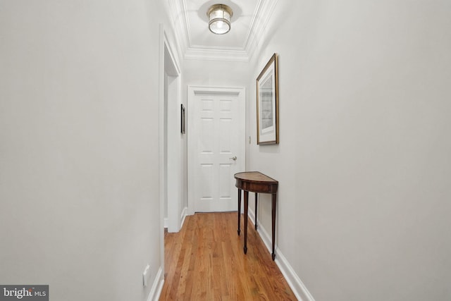 corridor featuring crown molding, baseboards, and light wood finished floors