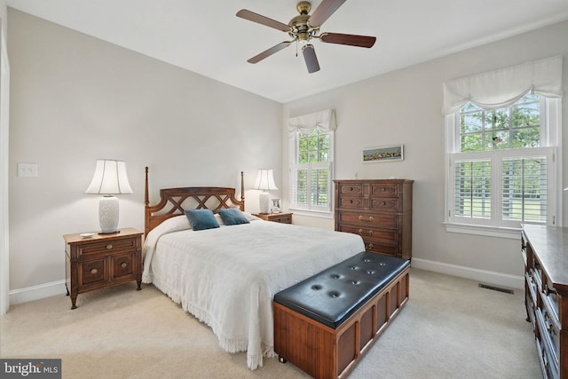 bedroom with baseboards, light carpet, and visible vents