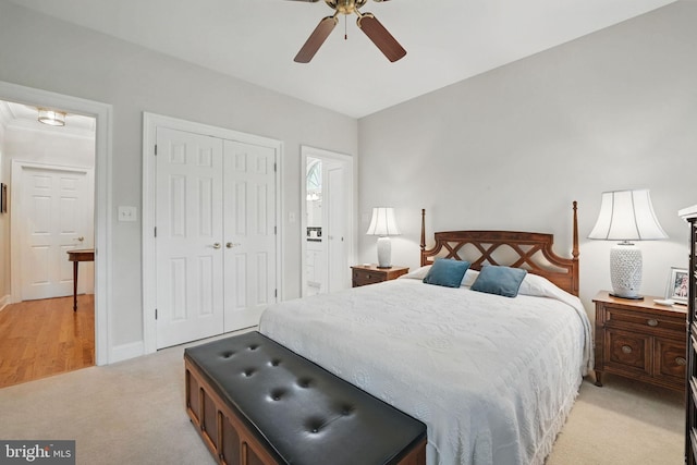 bedroom with a ceiling fan, baseboards, light carpet, and a closet