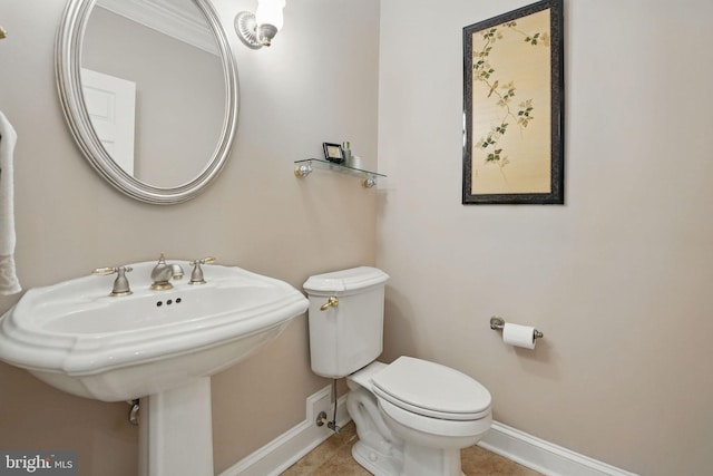 half bath featuring baseboards, tile patterned floors, and toilet
