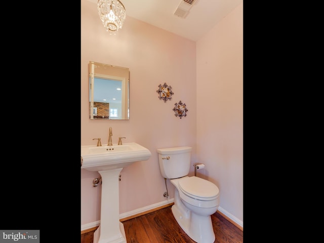 112 E Jefferson St E, Falls Church, VA 22046 - half bathroom with toilet, wood finished floors, baseboards, and a chandelier