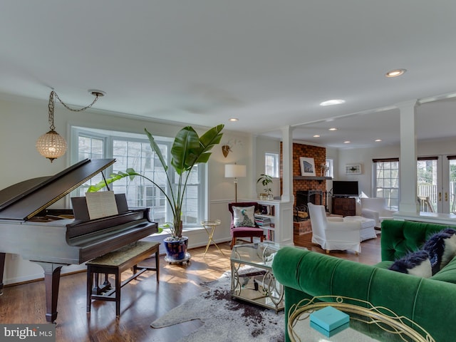 112 E Jefferson St E, Falls Church, VA 22046 - living room with a brick fireplace, ornate columns, wood finished floors, baseboards, and ornamental molding