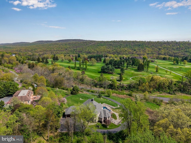 drone / aerial view with a forest view and golf course view