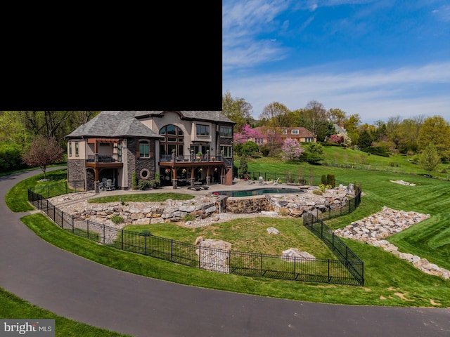 back of property with a lawn, a hot tub, a fenced in pool, a fenced backyard, and a patio