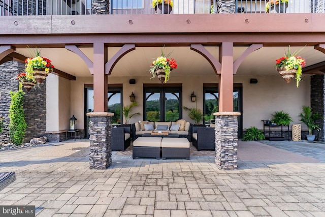 view of patio with an outdoor living space, french doors, and a balcony