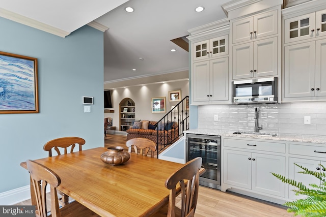360 Fishing Creek Valley Rd, Harrisburg, PA 17112 - dining space featuring beverage cooler, crown molding, stairs, wet bar, and light wood finished floors
