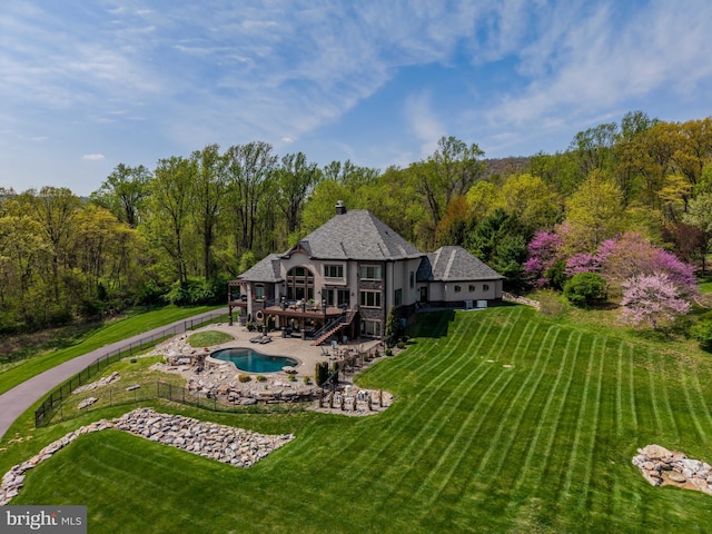 rear view of house featuring a patio area, fence, a fenced in pool, a yard, and stairs