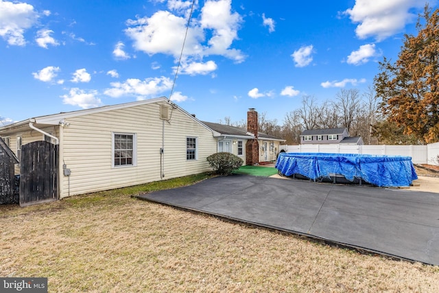 15700 Presswick Ln, Bowie, MD 20716 - view of home's exterior featuring a patio, a fenced in pool, a gate, a lawn, and fence