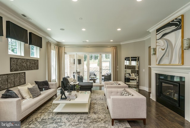 living area featuring crown molding, baseboards, a glass covered fireplace, recessed lighting, and wood finished floors