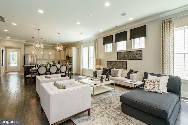 living area featuring visible vents, baseboards, recessed lighting, ornamental molding, and a notable chandelier