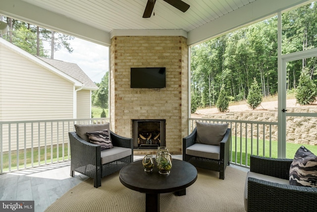 view of patio with a ceiling fan and an outdoor living space with a fireplace