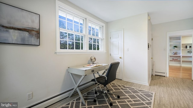 home office featuring light wood finished floors, a baseboard radiator, and baseboards