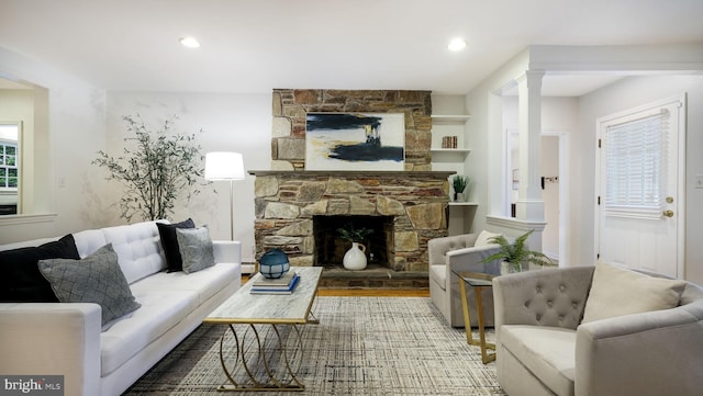 living area featuring wood finished floors, a fireplace, recessed lighting, and decorative columns