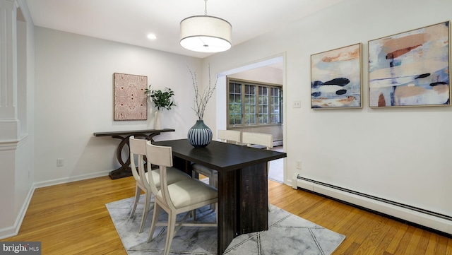 dining space with a baseboard radiator, light wood finished floors, recessed lighting, and baseboards