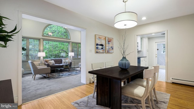 dining room featuring wood finished floors, baseboard heating, and recessed lighting