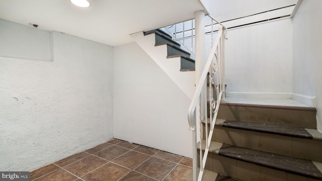 stairway with tile patterned flooring