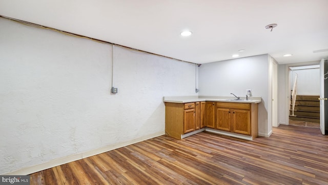 bar featuring a sink, wood finished floors, stairway, recessed lighting, and baseboards