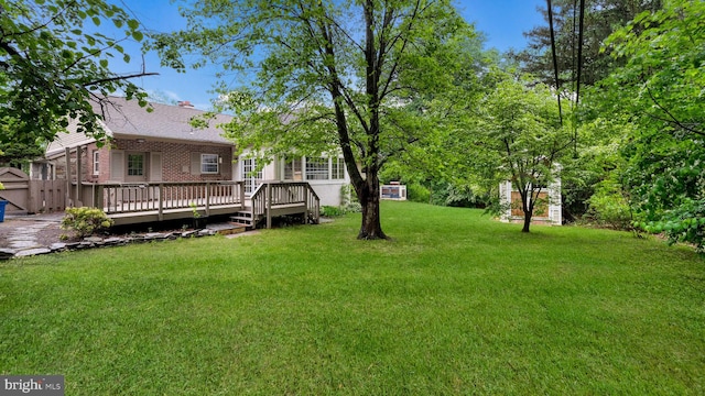 view of grassy yard with a deck
