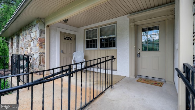 property entrance with stone siding and stucco siding