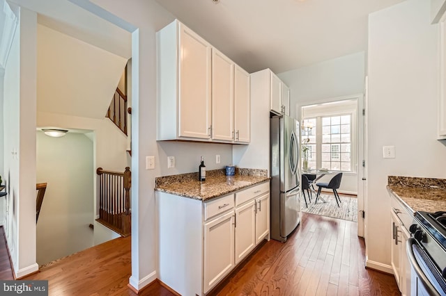 1308 Lowman St, Baltimore, MD 21230 - kitchen featuring appliances with stainless steel finishes, wood finished floors, white cabinetry, and light stone counters