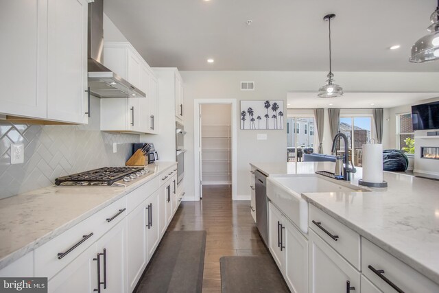 5510 Woodyard Rd, Upper Marlboro, MD 20772 - kitchen with stainless steel appliances, wall chimney range hood, a sink, white cabinets, and backsplash