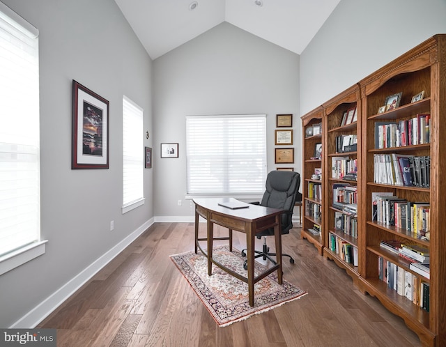 office area with dark wood-style flooring, baseboards, and high vaulted ceiling